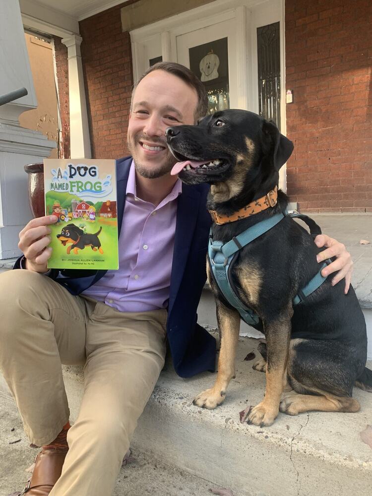 Joshua Lanham with Sirius and a copy of A Dog Named Frog