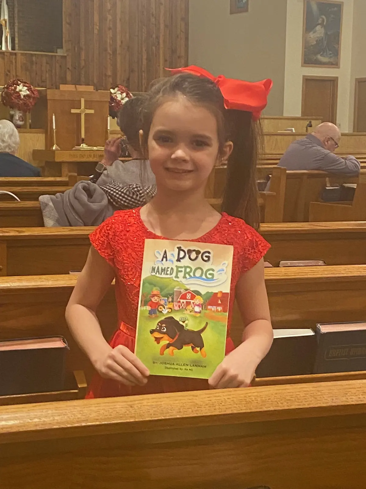 A young reader proudly holding A Dog Named Frog
