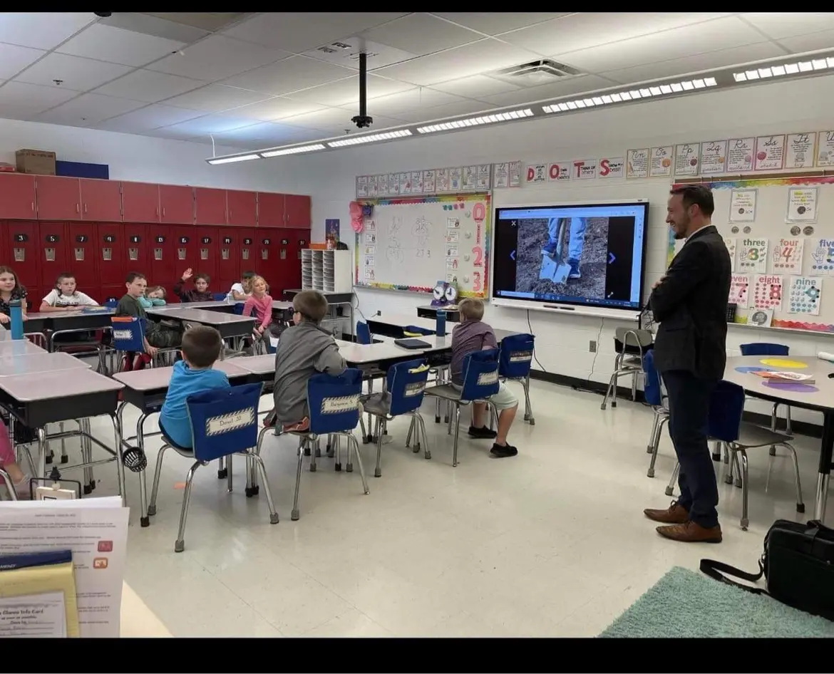 Joshua speaking with elementary students during a school visit